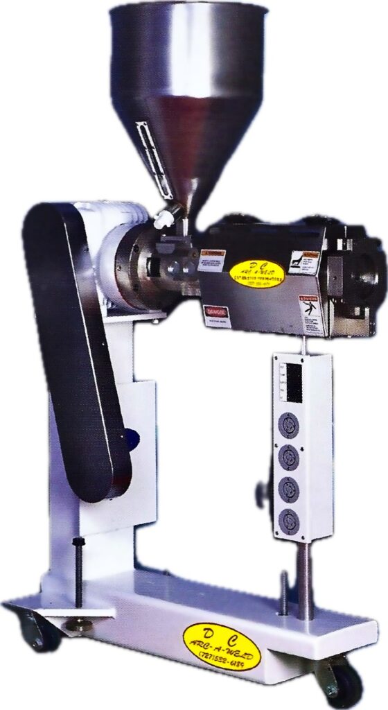 A large industrial mixing machine with a conical metal hopper on top, mounted on a wheeled base. The machine is metallic with visible control dials.